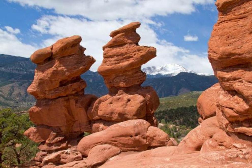 The red stone formations in the Garden of the Gods in Colorado Springs, USA are its most popular attraction. Pikes Peak stands snow frosted in the background.