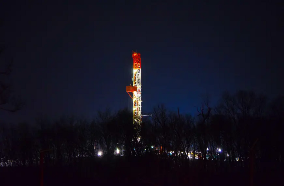 A hydraulic fracturing drilling rig in western Pennsylvania at night.