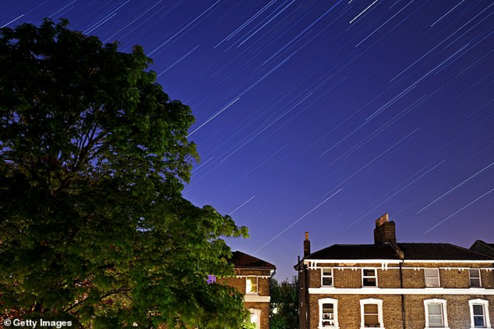 Space is also putting on a show this evening with the peak of the stunning Lyrid meteor shower that is set to see up to 18 shooting stars streaking across the sky every hour from about midnight. Pictured is Forest Hill illuminated under the shooting stars