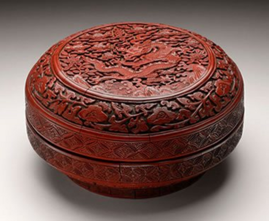 Chinese red (cinnabar) lacquer box: A carved wooden box with a red lacquer finish from China's Ming Dynasty Period (box c. 1522-1566). Boxes like this were frequently painted with a lacquer containing a cinnabar pigment.