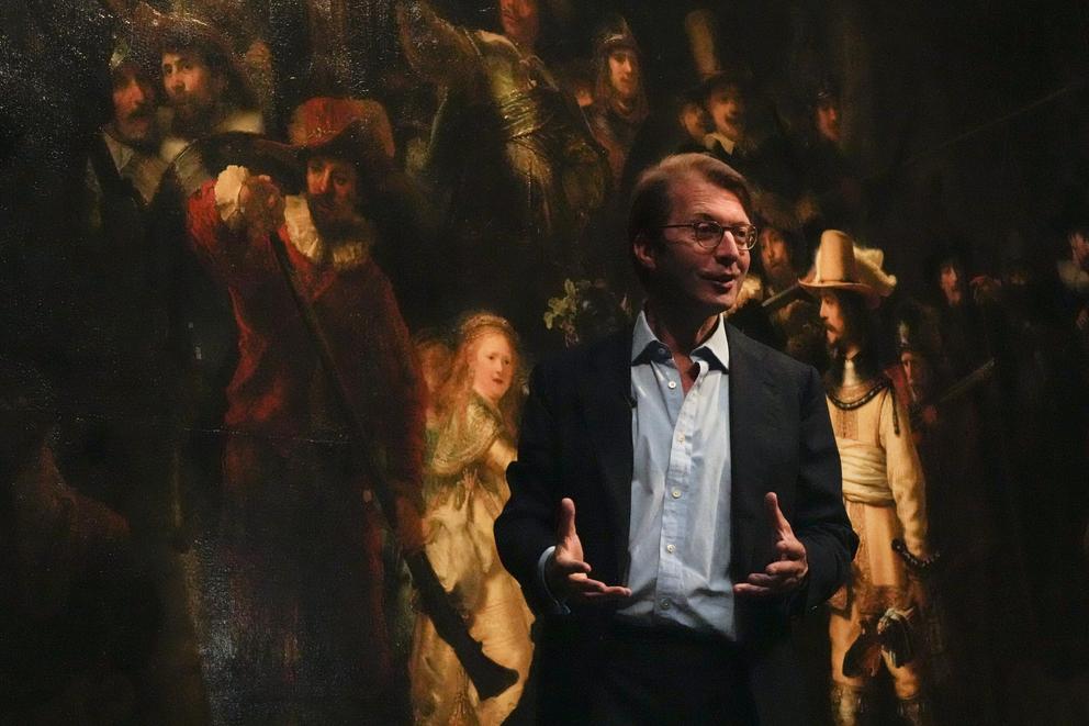 Museum director Taco Dibbits explains how Rembrandt's biggest painting the Night Watch just got bigger with the help of artificial intelligence in Amsterdam, Netherlands, Wednesday, June 23, 2021. Right above Dibbits, left, one of the added parts is seen,