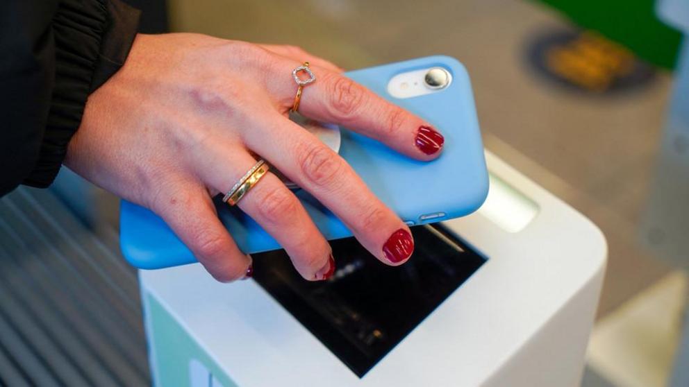 FILE PHOTO. A customer scans a QR on their phone. © AFP / Niklas HALLE'N