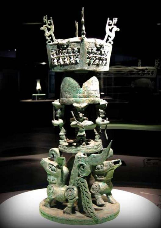 This bronze altar previously unearthed at the Sanxingdui Ruins site consists of 3 levels: the bottom level is a circular base bearing a pair of fabulous animals, on the second level are 4 standing human figures supporting hills on their heads. The top lev