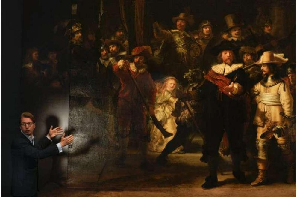 Museum director Taco Dibbits explains how Rembrandt's biggest painting the Night Watch just got bigger with the help of artificial intelligence in Amsterdam, Netherlands, Wednesday, June 23, 2021. Right above Dibbits, left, one of the added parts is seen,