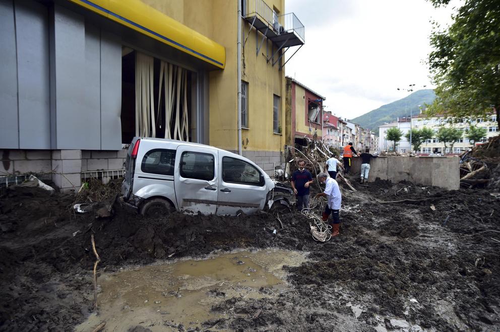 People watch the destruction after floods and mudslides killed about three dozens of people, in Bozkurt town of Kastamonu province, Turkey, Friday, Aug. 13, 2021.