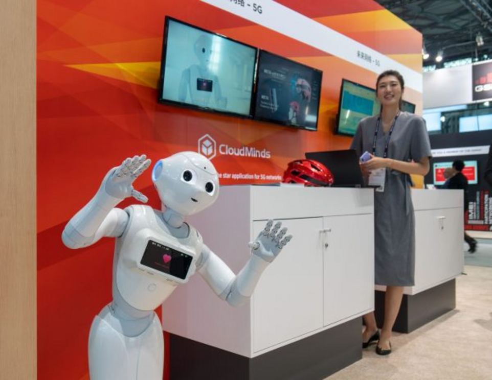 An AI robot (L) by CloudMinds is seen during the Mobile World Conference in Shanghai on June 27, 2018.