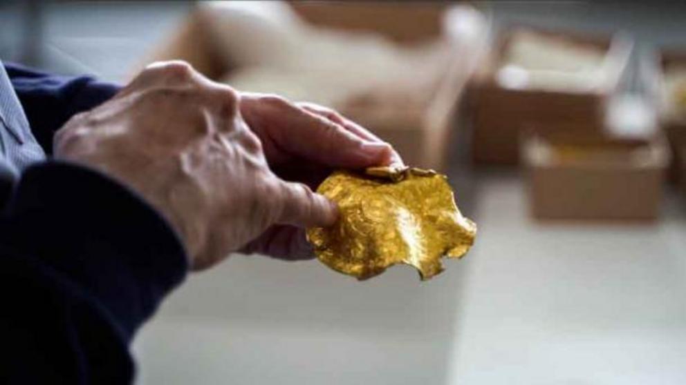 Researcher examines part of the golden treasure hoard.