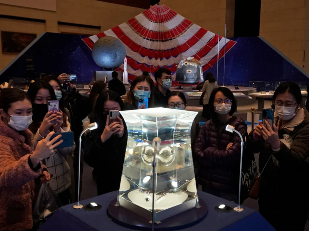 Visitors to the National Museum in Beijing look at a display of lunar rock samples from China’s Chang’e 5 mission, March 12, 2021.