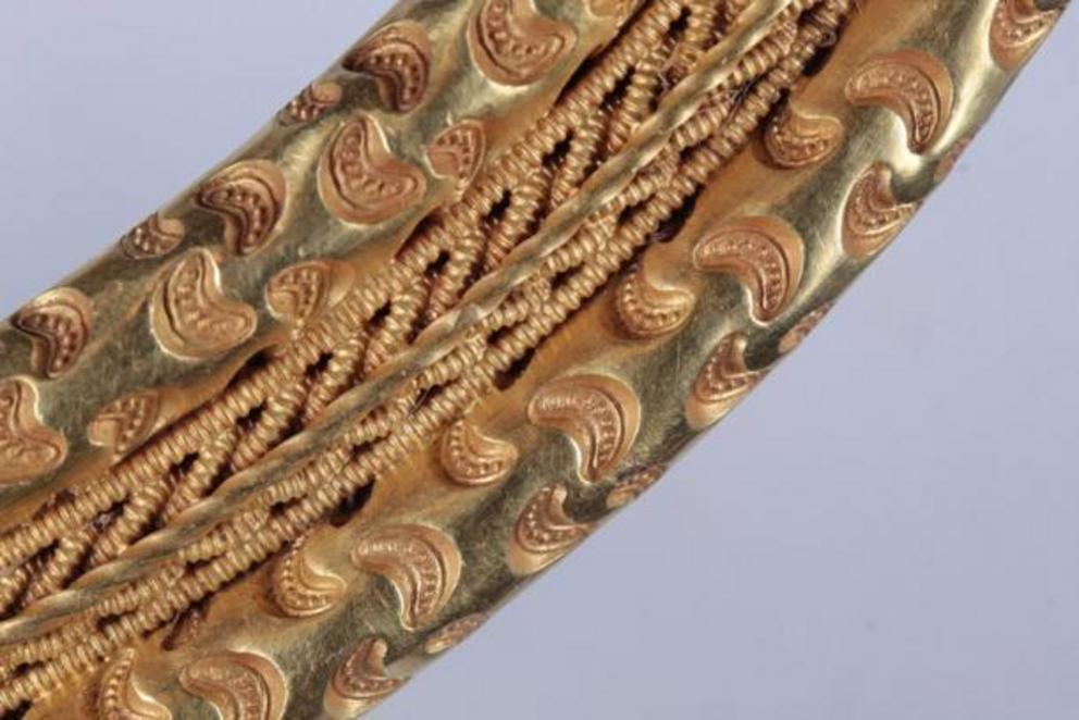 Detail of the crescent shaped embossing and plaited gold wire frieze.