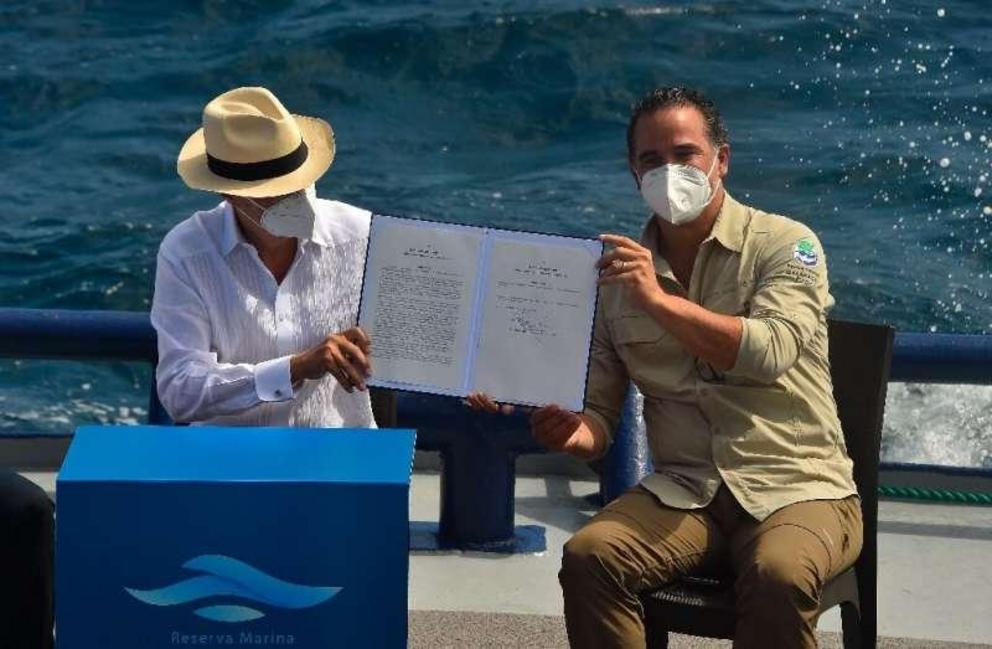 Ecuador's President Guillermo Lasso (L) and Environment Minister Gustavo Manrique show the decree for the expansion of the Galapagos marine reserve.