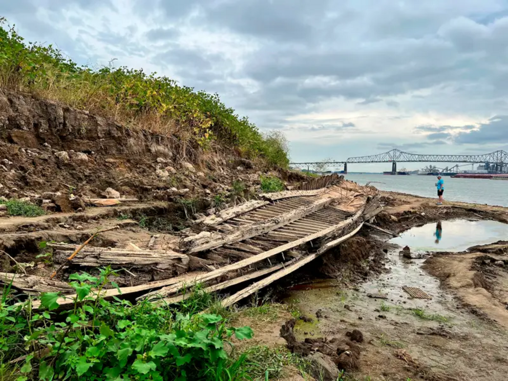 A man walking along the Mississippi River in Baton Rouge, Louisiana, stops to look at a shipwreck revealed by the low water level in October. 