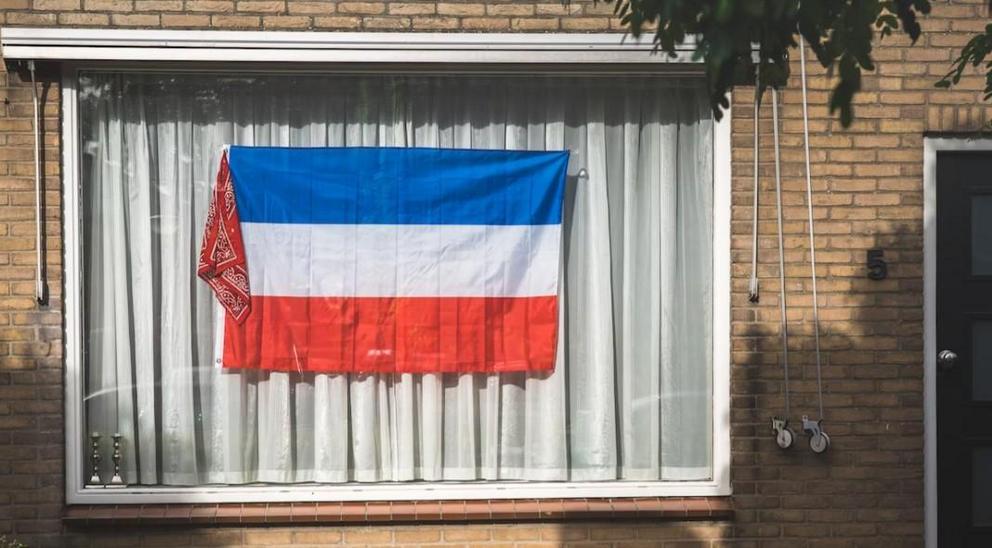 Dutch flag displayed in the window of a farm dwelling. Photo credit: Ewien van Bergeijk – Kwant