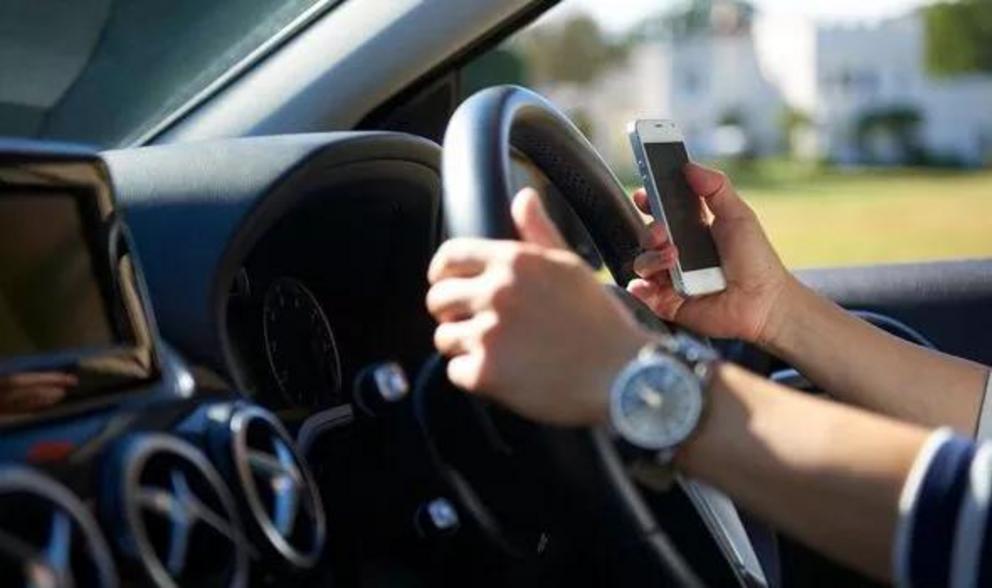 Drivers are now banned from even touching phones behind the wheel other than in emergencies (Image: Getty)