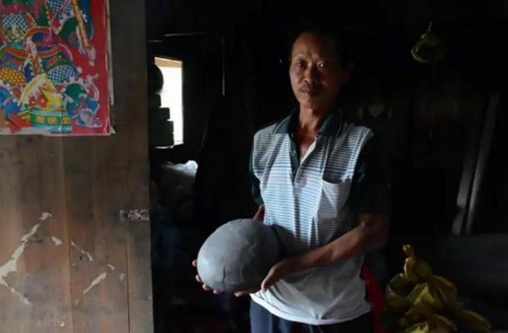 Local resident with one of the stone eggs from the egg-laying mountain in China.