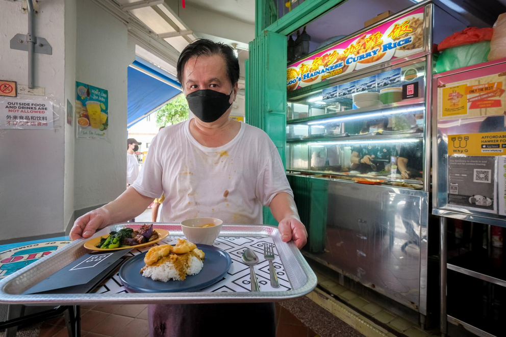 Loo’s Hainanese Curry Rice owner Loo Kia Chee holding a plate of curry rice with the Good Meat on rice at his stall in Tiong Bahru, on March 1, 2022.