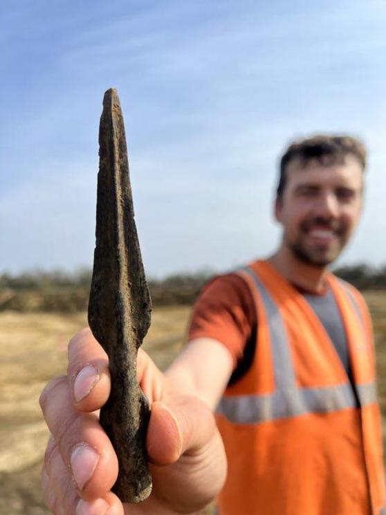 Archaeologist Joe Price holding the Bronze Age spearhead they discovered recently.