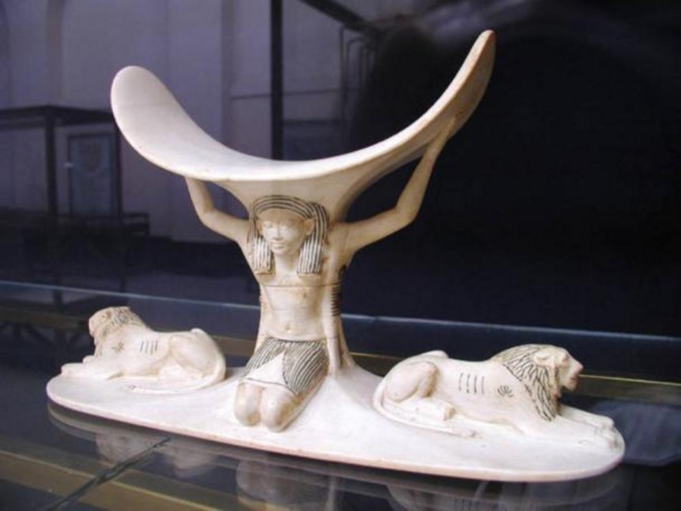 One of eight headrests found in the tomb of Tutankhamun, this elaborately carved ivory headrest depicts the god Shu supporting the carved element where the king’s head would have rested.