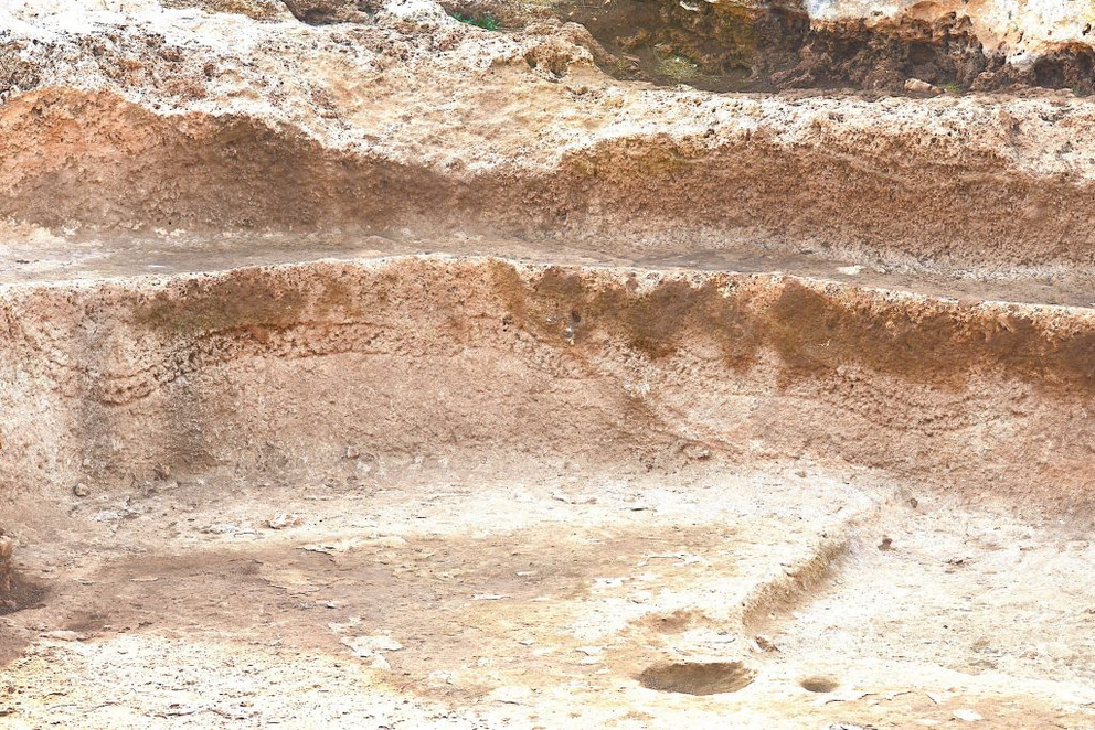 The undulating body of a serpent coils across the base of a water-channel