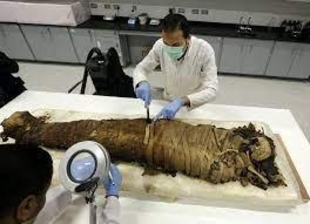 Egyptian conservators clean a female mummy dated to Pharaonic late period, (712-323 BC), in the conservation centre of Egypt’s Grand Museum.