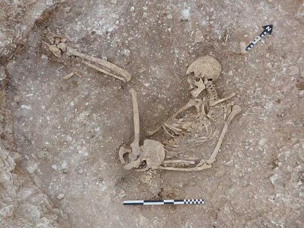 A human skeleton in an oval pit at Duropolis.