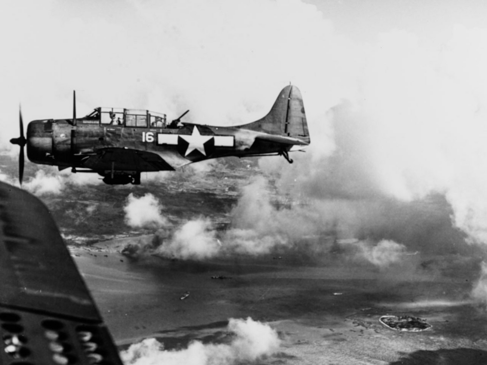 A bomber flies over Tanapag Harbor during the Battle of Saipan on 15 June 1944.