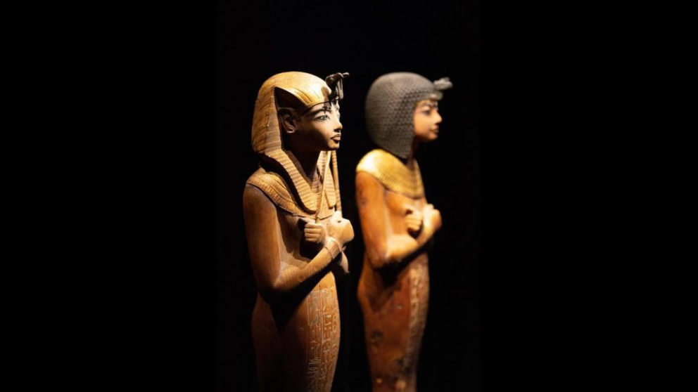 A shabtis with a headdress and another wearing a Nubian wig.
