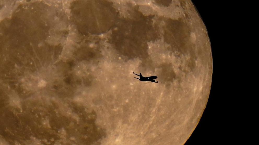 In this July 13, 2022 file photo, a plane passes in front of a full moon in Milwaukee. (AP Photo/Morry Gash) 