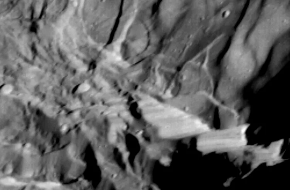 La parete rocciosa di Verona Rupes (a destra) catturata dal Voyager nel 1986. Situata sulla luna Miranda, si stima che la meraviglia geologica sia alta almeno 12 miglia