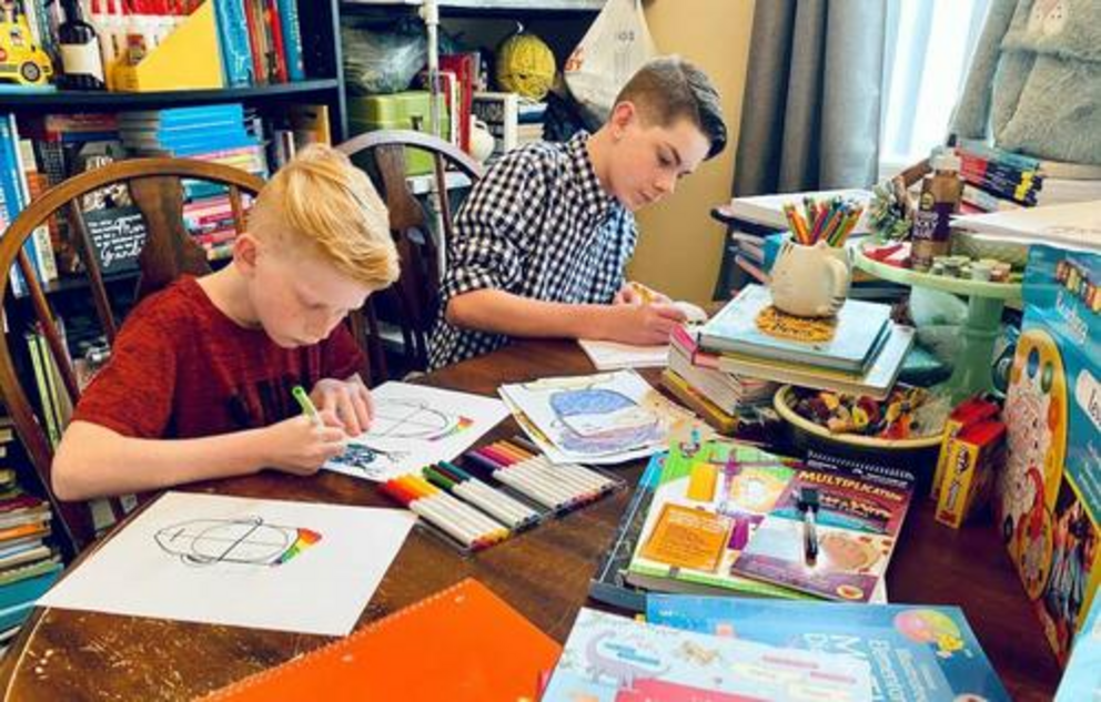 From left, brothers Nealan and Justice Boyd work to create a book about the arts, a project led by a local home schooling co-op run by their mother, Lori Boyd, in Pulaski County, Ky.