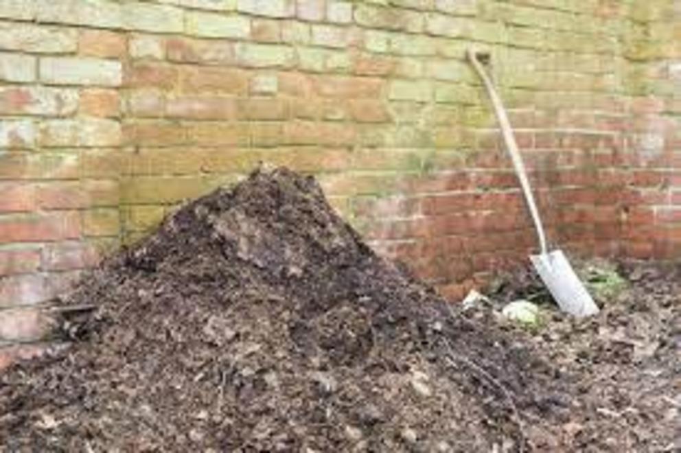 Homemade garden compost heap with leaf mold for use as organic fertilizer.