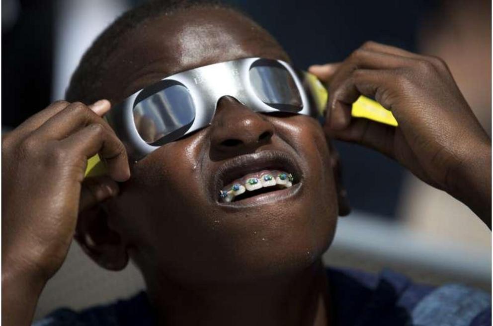 Blake Davis, 10, of Coral Springs, Fla., looks through solar glasses as he watches the eclipse, Monday, Aug. 21, 2017, at Nova Southeastern University in Davie, Fla. It’s only a year until a total solar eclipse sweeps across North America. On April 8, 202