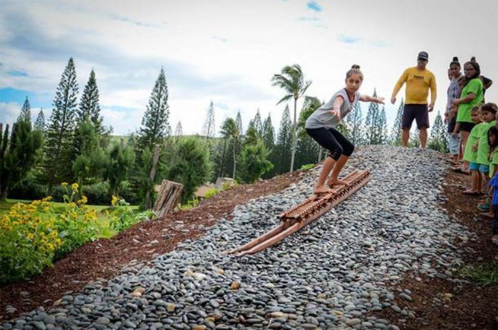 A workshop teaching he'e holua lava sledding using a papa holua sled and riding down a reconstructed kahua holua sledding track.