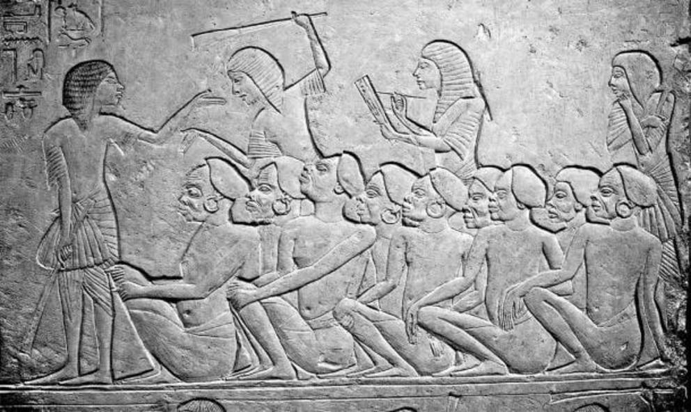 Relief showing Ancient Egyptian slave market, with Nubian slaves waiting to be sold. Archaeological Museum, Bologna.