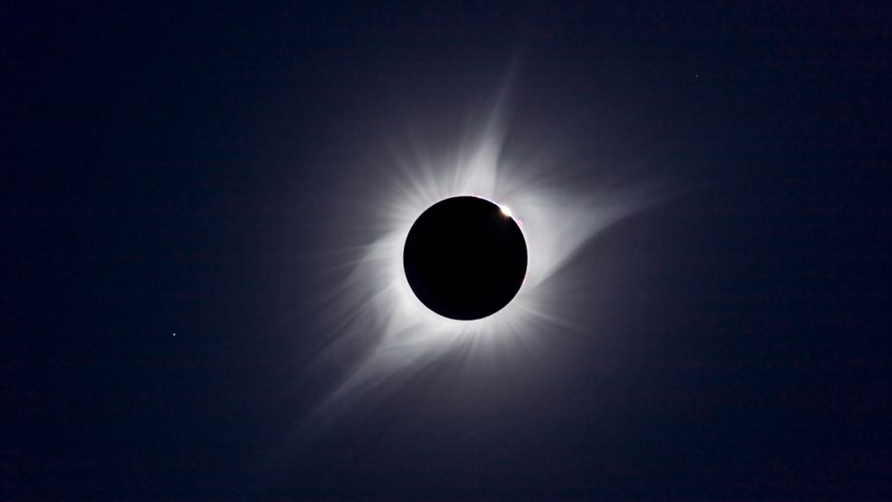 A composite of the August 21, 2017 total solar eclipse showing third contact – the end of totality – with sunlight beginning to reappear and the array of pink prominences along the limb of the Sun Seconds later the emerging Sun and diamond ring overwhelme