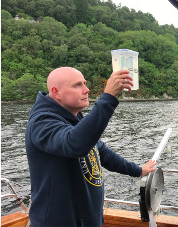 Neil Gemmell inspects a collected water sample aboard the Deepscan. | Photo by Ellie Rowley